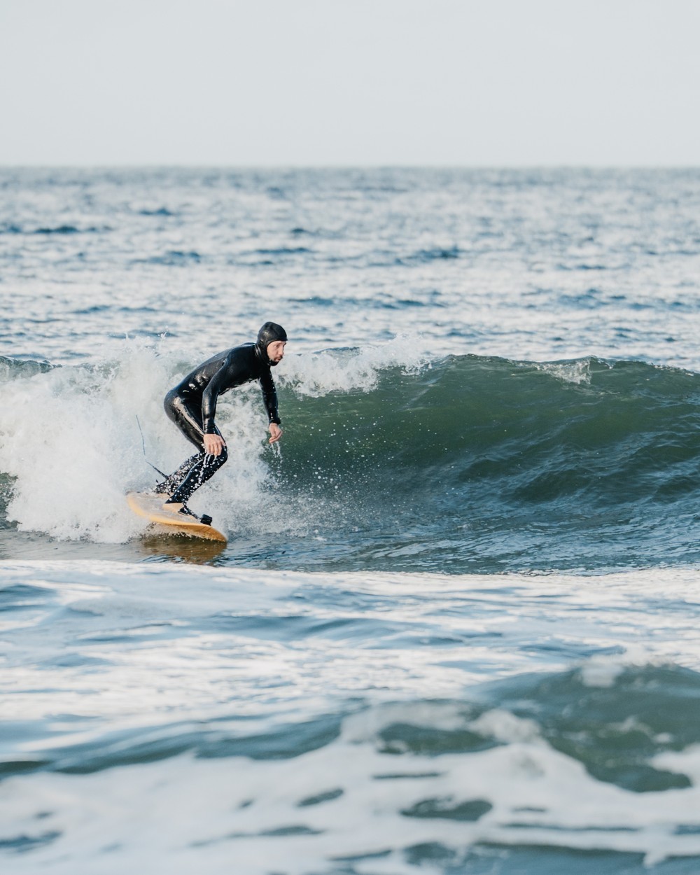 Surfer na bałtyckiej fali na desce Indio
